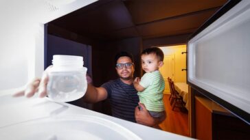 Kazi Albab Hussain segura seu filho enquanto remove um recipiente de plastico com agua de um micro ondas Craig Chandler Universidade Comunicacao e Marketing